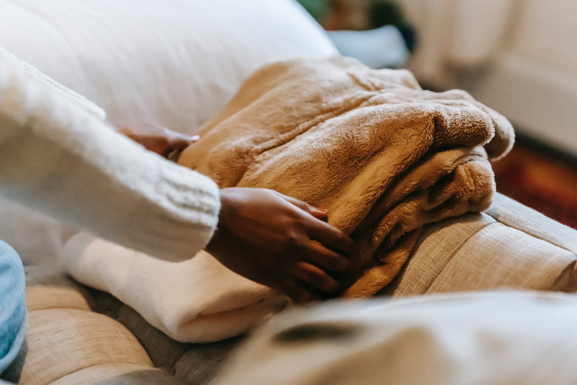 black woman stacking clothes on sofa